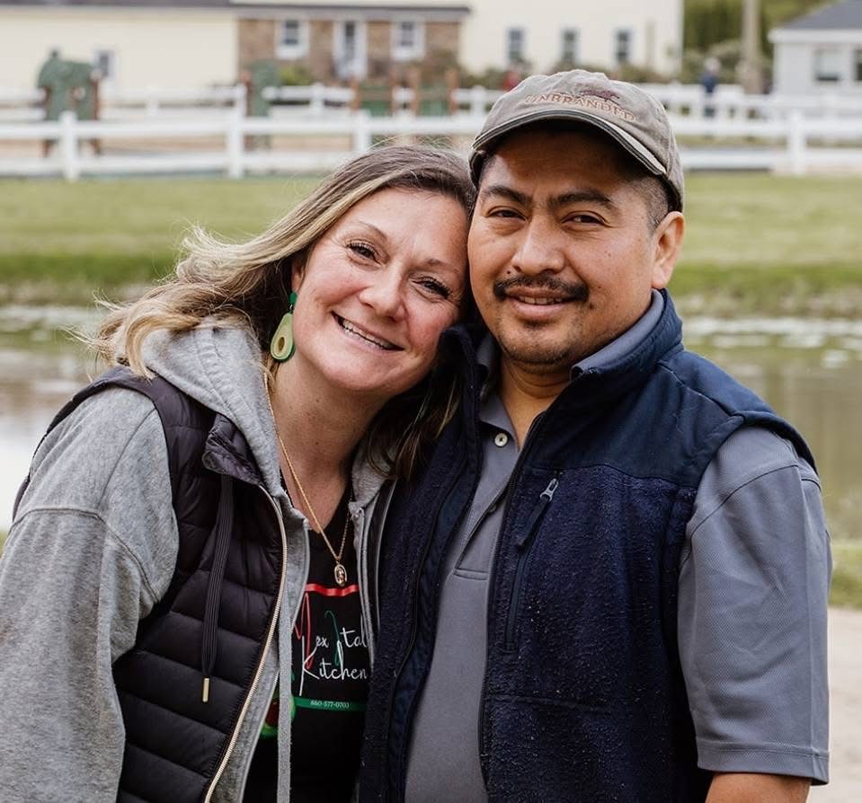 Owners of MexItalē Kitchen — a smiling husband-and-wife team outside their Guilford, CT restaurant